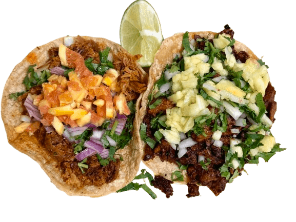 Two Mexican street tacos with marinated pork, pineapple, onion, cilantro, and lime, served fresh in Chicago.