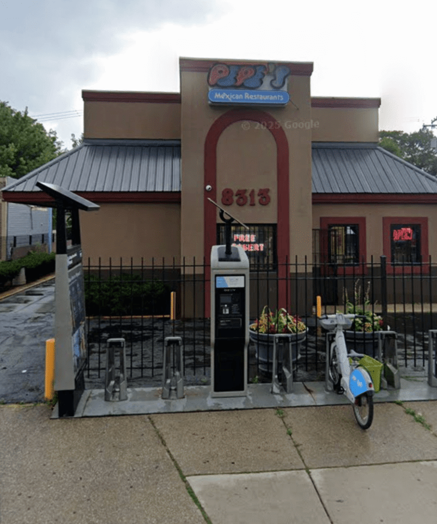 Exterior view of Pepe’s Mexican Restaurant with arched entrance, brick details, and colorful logo sign above the door.
